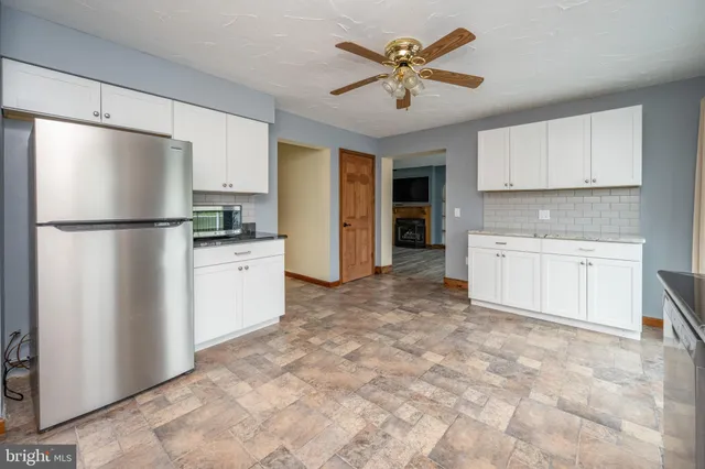 a kitchen with granite countertop white cabinets and a window