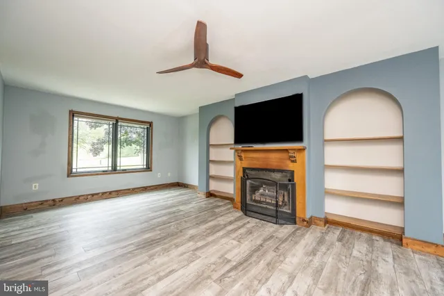 a view of a room with wooden floor and a window