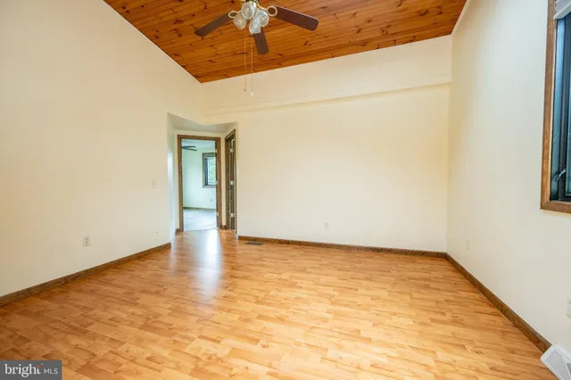 a view of empty room with wooden floor and window