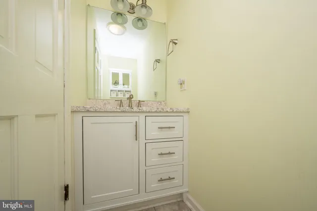 a bathroom with a toilet a sink a mirror and vanity