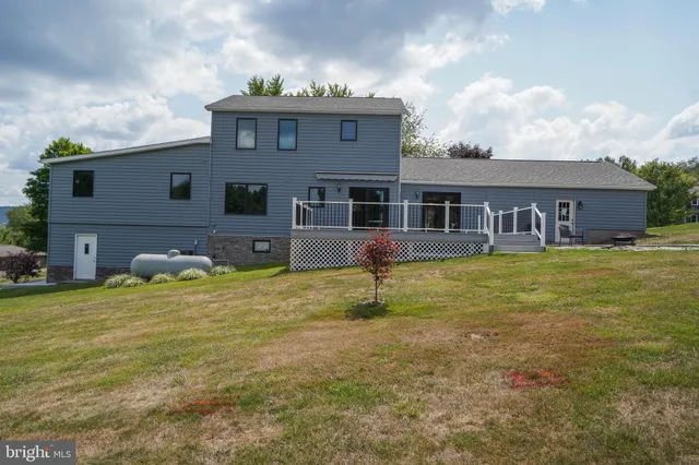 a house view with swimming pool and trees in the background
