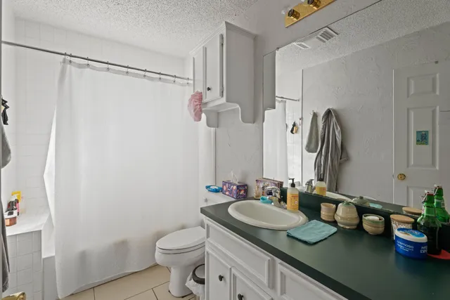 a bathroom with a granite countertop sink toilet and shower