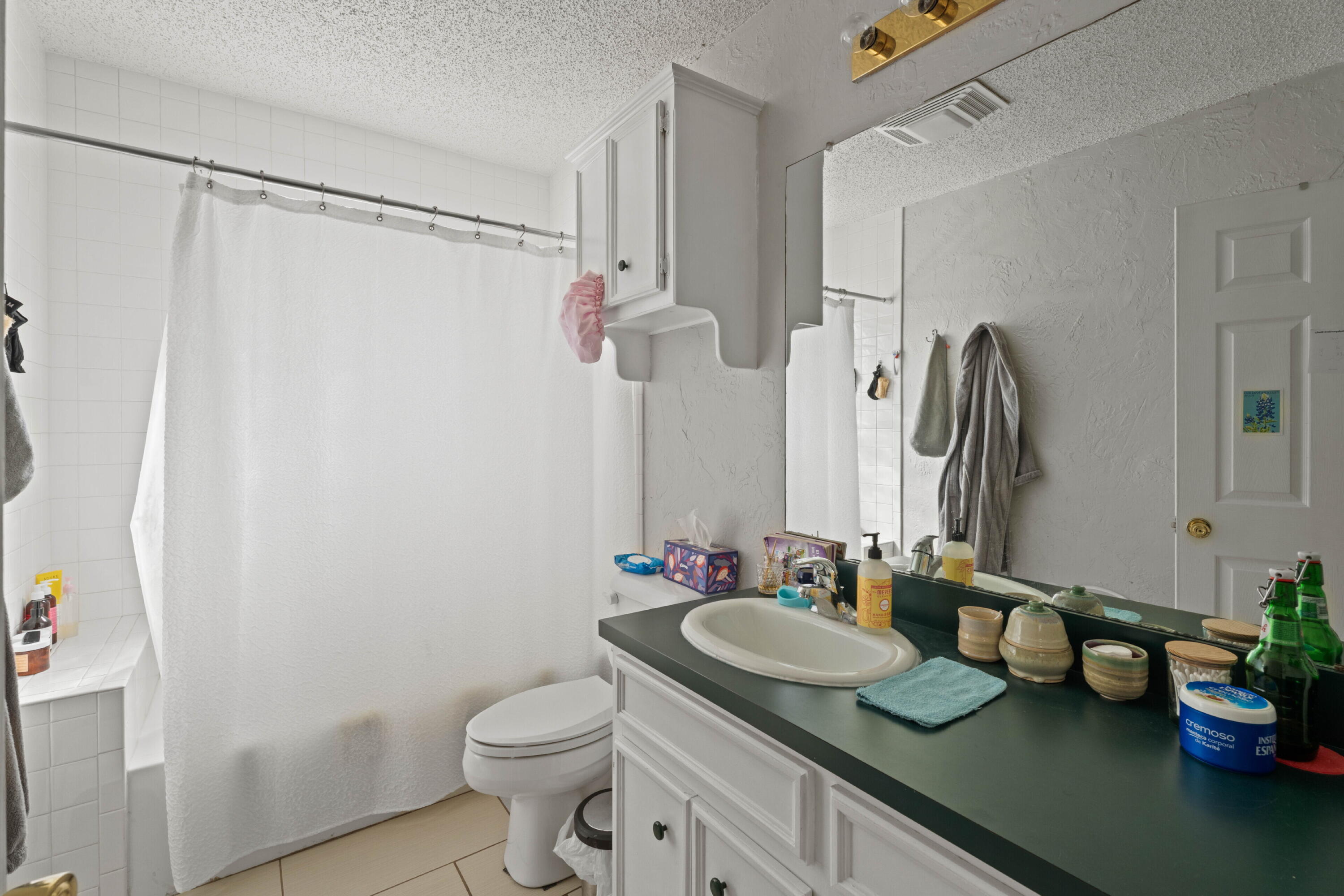 2703 23rd Street Lubbock, TX 79410 - Photo 9 of 11 a bathroom with a granite countertop sink toilet and shower