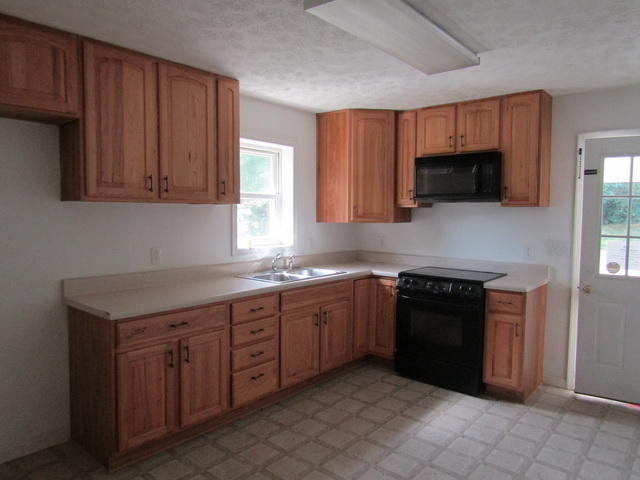3633 Childress Road Christiansburg, VA 24073 - Photo 4 of 17 a kitchen with stainless steel appliances granite countertop wooden cabinets a stove top oven a sink and dishwasher