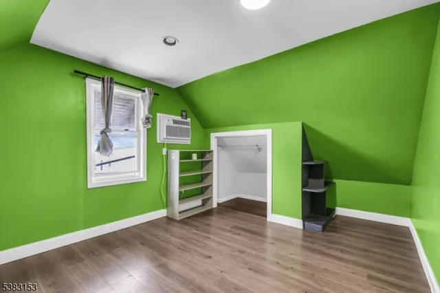 a view of an empty room with kitchen and a window