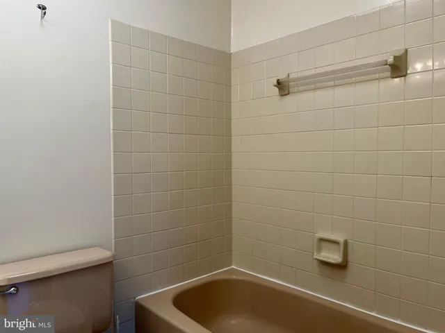 a bathroom with a white bath tub and a toilet
