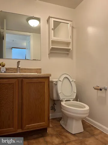 a bathroom with a toilet a sink and mirror