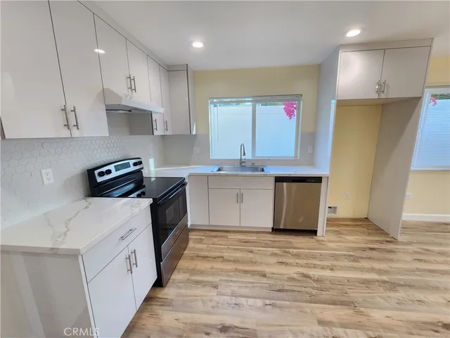 a kitchen with stainless steel appliances granite countertop a stove a sink and a refrigerator