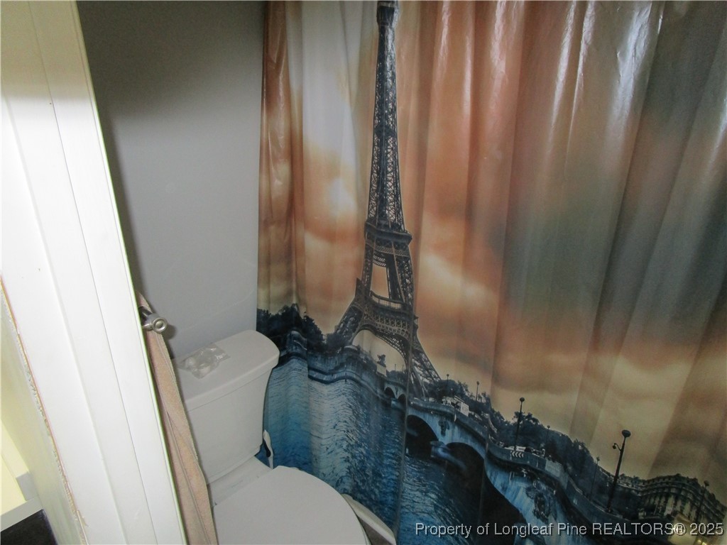 821 Rock Spring Road Fayetteville, NC 28314 - Photo 14 of 23 a bathroom with a toilet and shower curtain