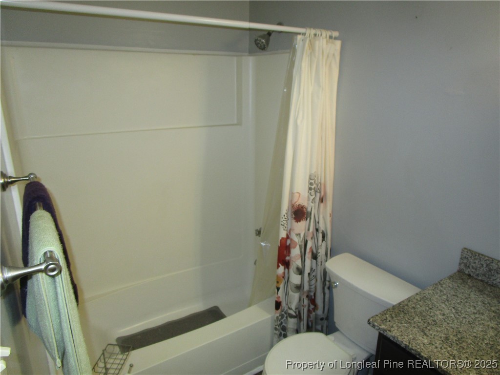 821 Rock Spring Road Fayetteville, NC 28314 - Photo 8 of 23 a bathroom with a shower curtain and a toilet