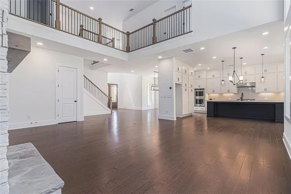 a view of a living room and kitchen with a sink wooden floor and a large window