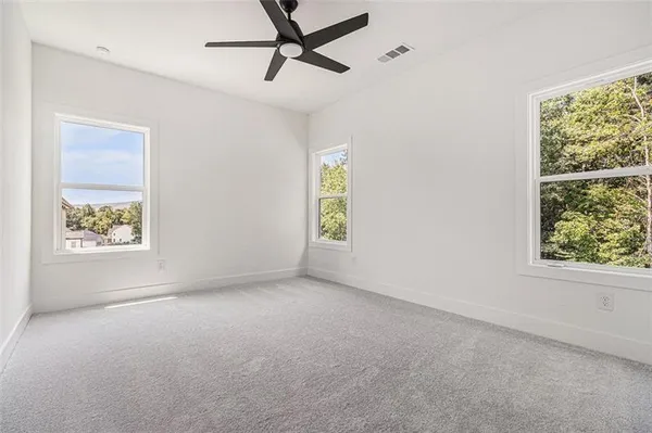 an empty room with a window and a ceiling fan