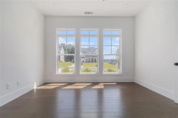 an empty room with wooden floor and glass door