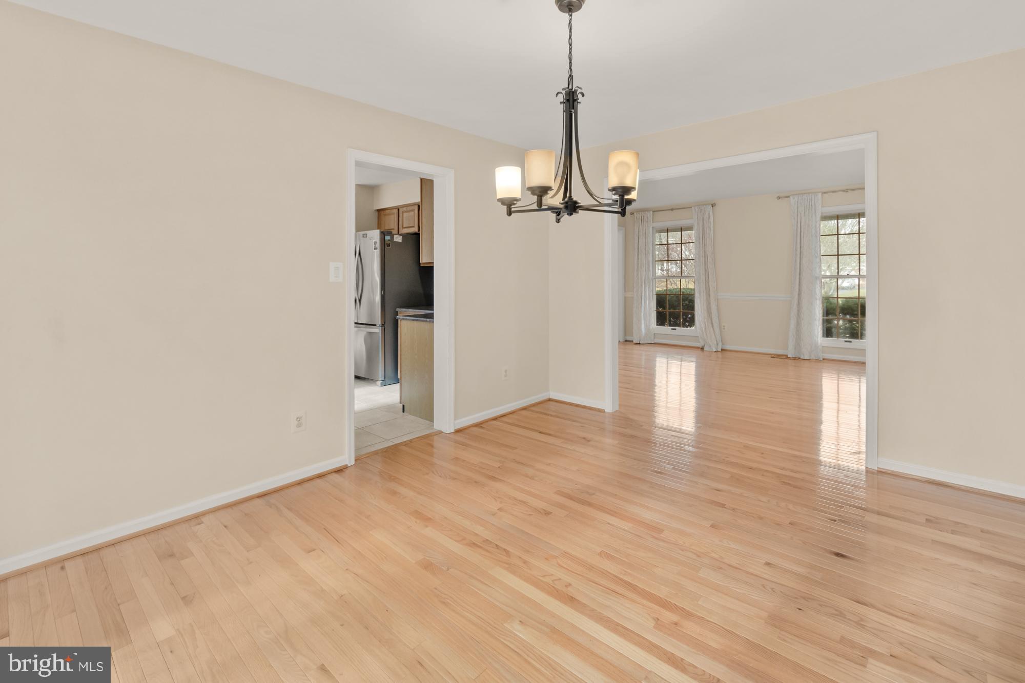 16908 Hoskinson Road Poolesville, MD 20837 - Photo 33 of 72 a view of an empty room with wooden floor kitchen view and a window