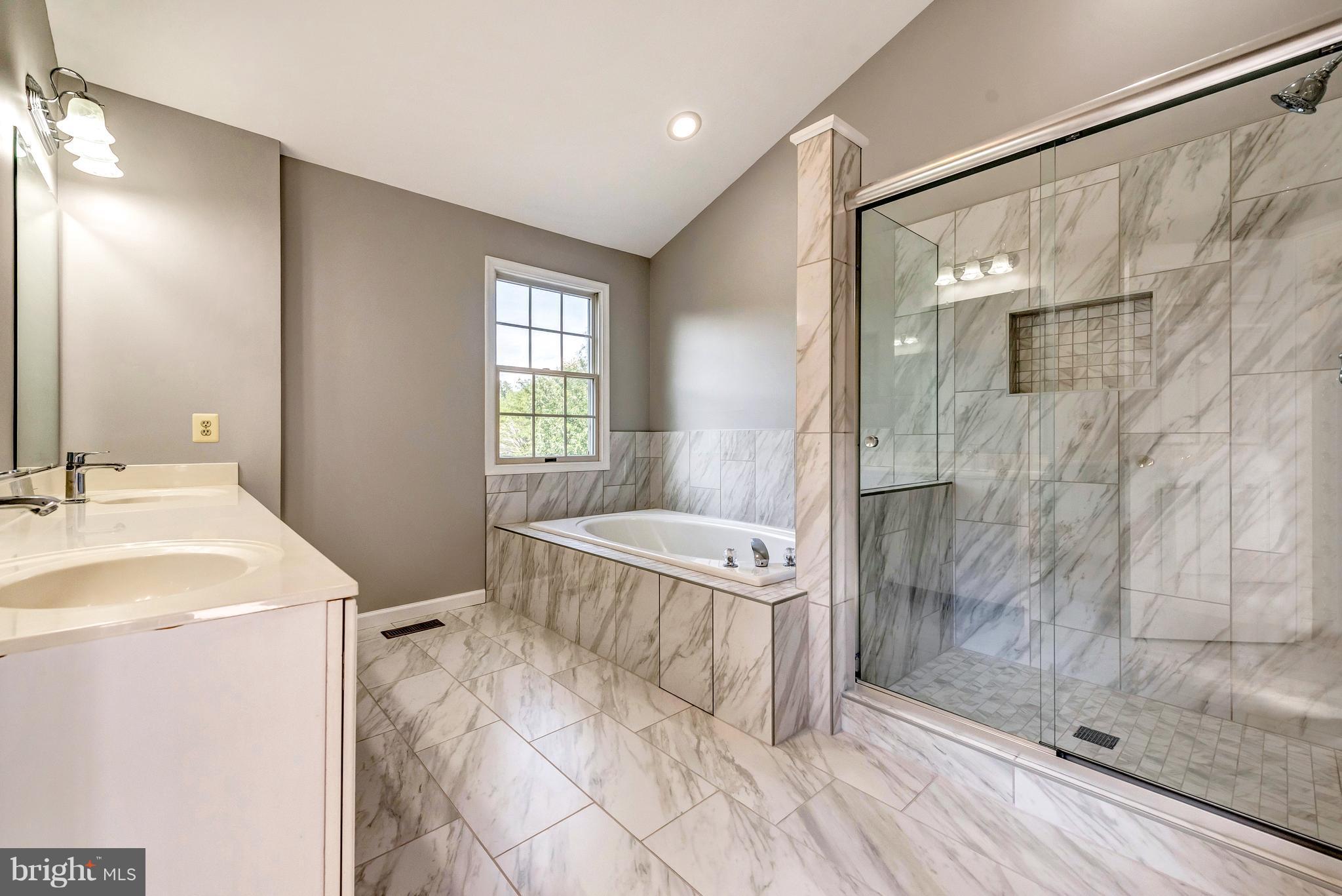 16908 Hoskinson Road Poolesville, MD 20837 - Photo 42 of 72 a spacious bathroom with a granite countertop sink a toilet a mirror and shower
