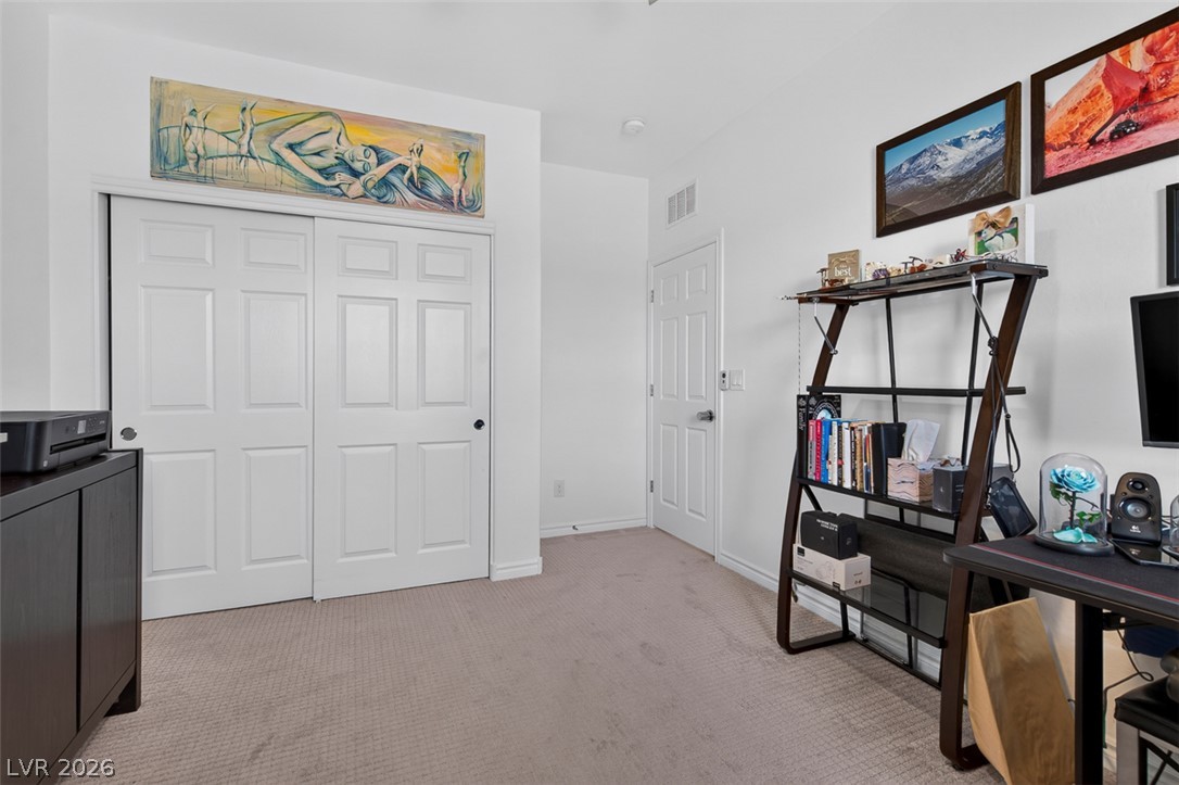 1824 Redland Ridge Street Henderson, NV 89002 - Photo 48 of 69 Well-appointed bedroom featuring practical closet doors, plush carpet, and ample space for a home office setup.