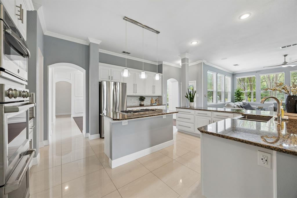 5808 Rathbone Drive Parker, TX 75002 - Photo 10 of 39 The spacious kitchen is open to the family room and has direct access to the dining room via the butler's pantry. The space boasts granite countertops, stunning tile backsplash and modern pendant lights.