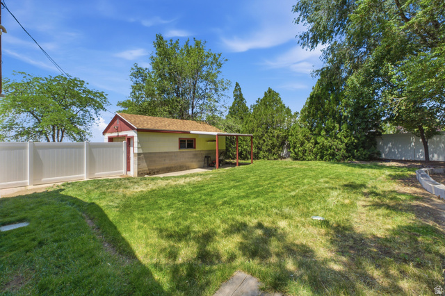94 West 2000th Street North Clearfield, UT 84015 - Photo 22 of 26 Spacious backyard with mature greenery, detached garage, and room for outdoor enjoyment.
