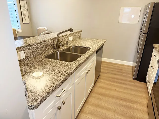 a kitchen with stainless steel appliances granite countertop a stove microwave and refrigerator