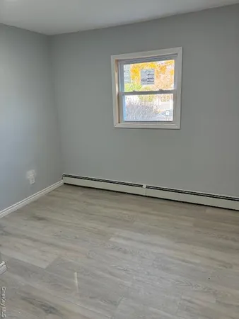 a view of a room with wooden floor and a window