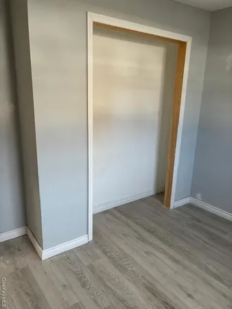 an empty room with wooden floor and closet