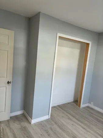 an empty room with wooden floor and entrance