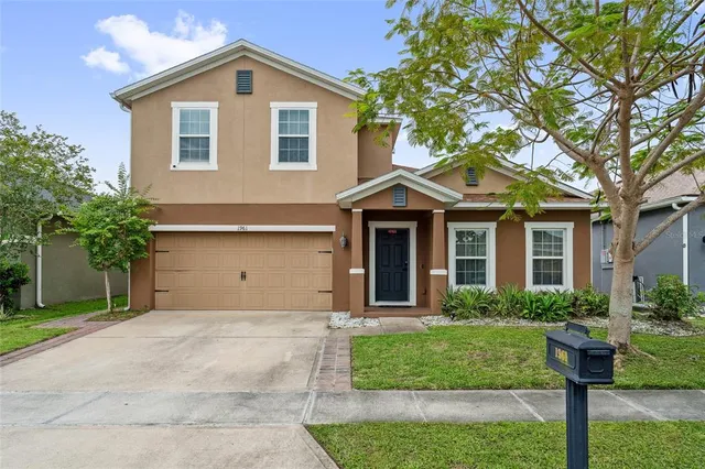 a front view of a house with a yard and trees