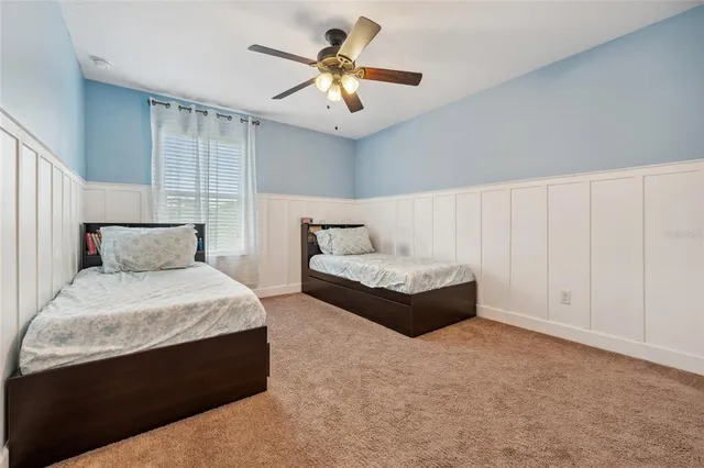 a spacious bedroom with a bed and a ceiling fan