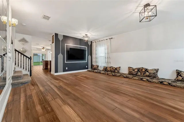 a view of a room with wooden floor and a flat screen tv