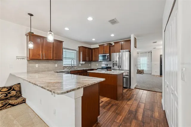 a kitchen with stainless steel appliances granite countertop a sink stove and refrigerator