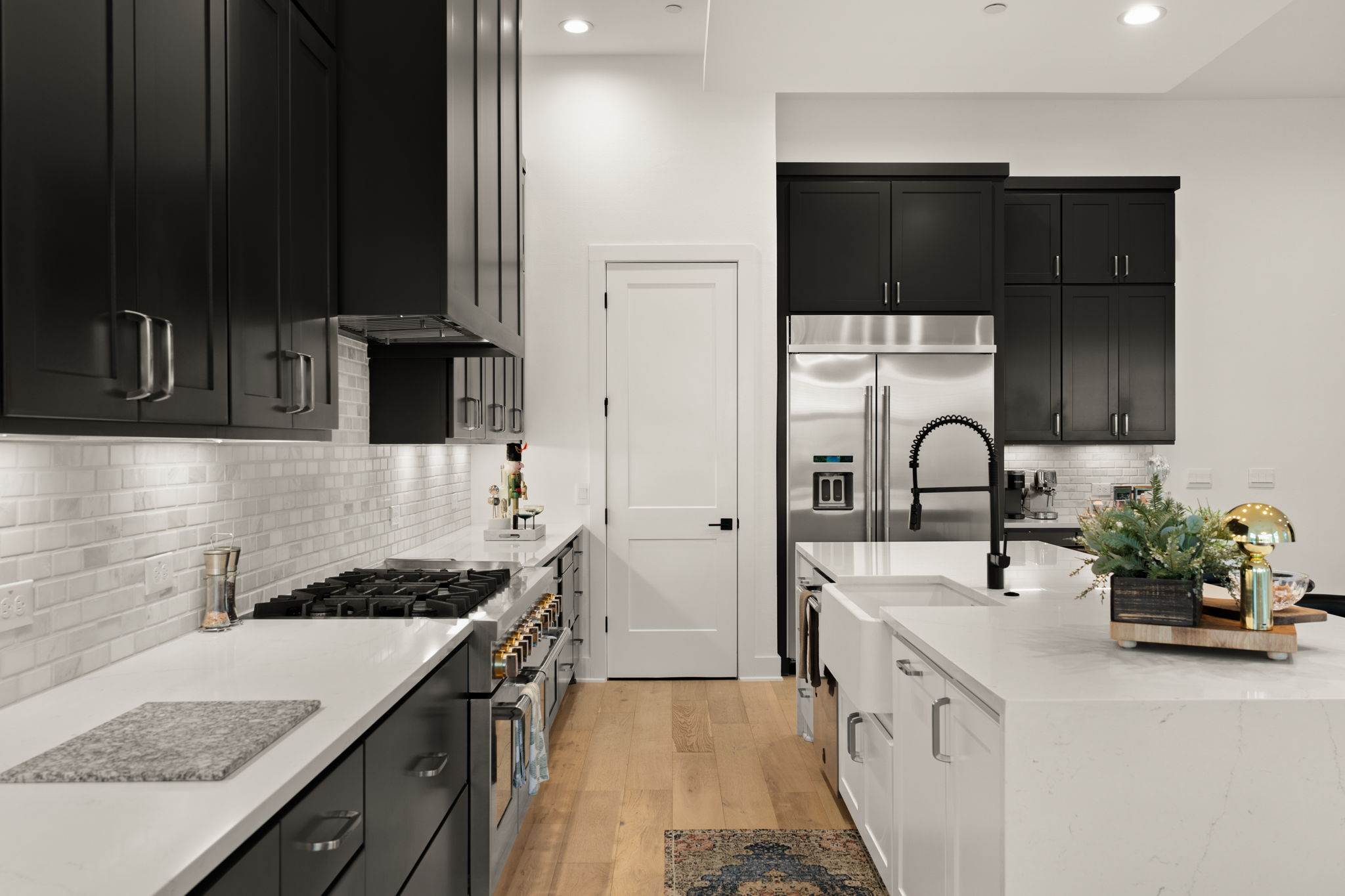 4003 Independent Way, Unit 182 Austin, TX 78731 - Photo 11 of 40 Kitchen featuring dark cabinetry, light stone counters, premium appliances, light wood-style flooring, and recessed lighting