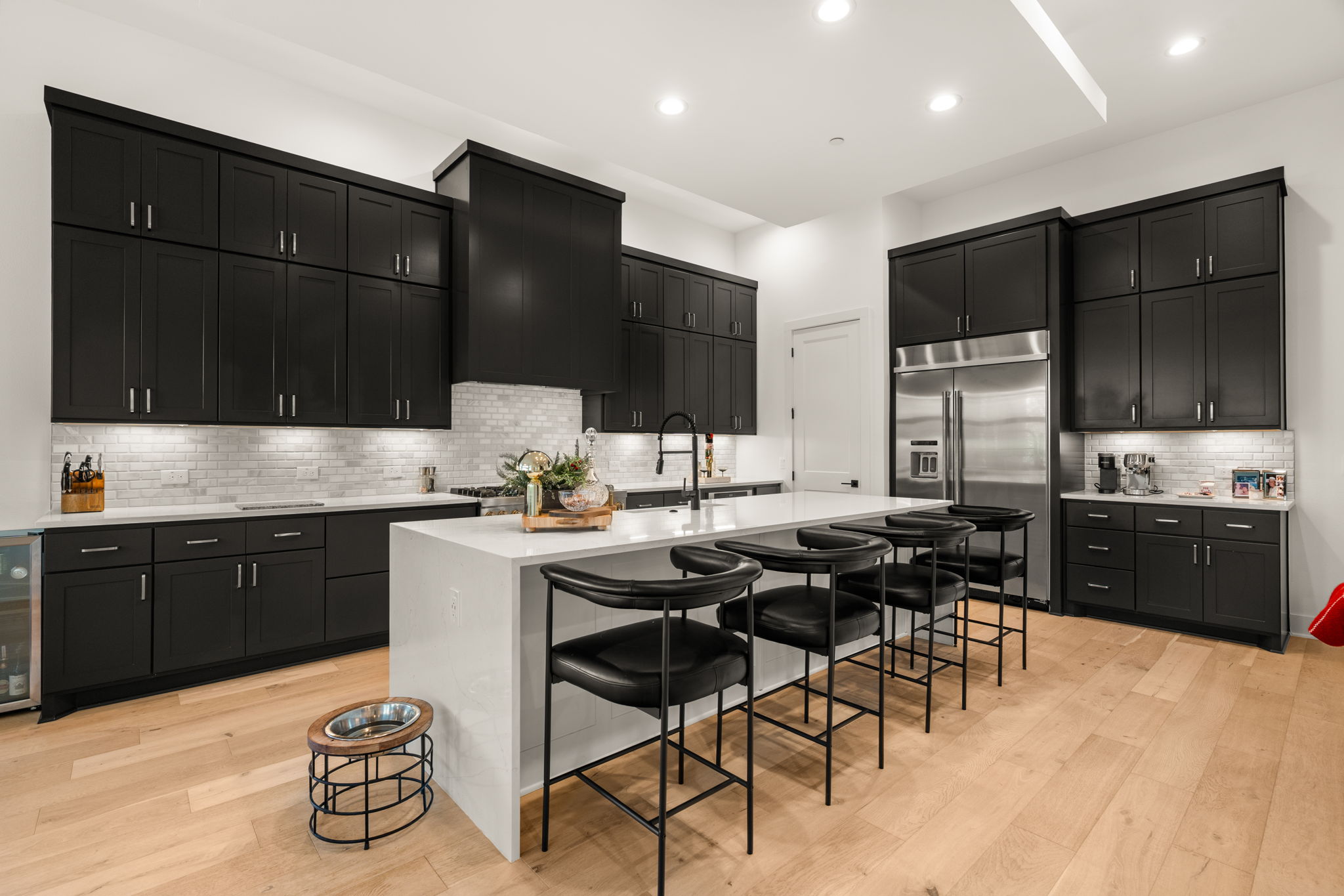 4003 Independent Way, Unit 182 Austin, TX 78731 - Photo 7 of 40 Kitchen with dark cabinets, a breakfast bar, a center island with sink, built in refrigerator, and light stone counters