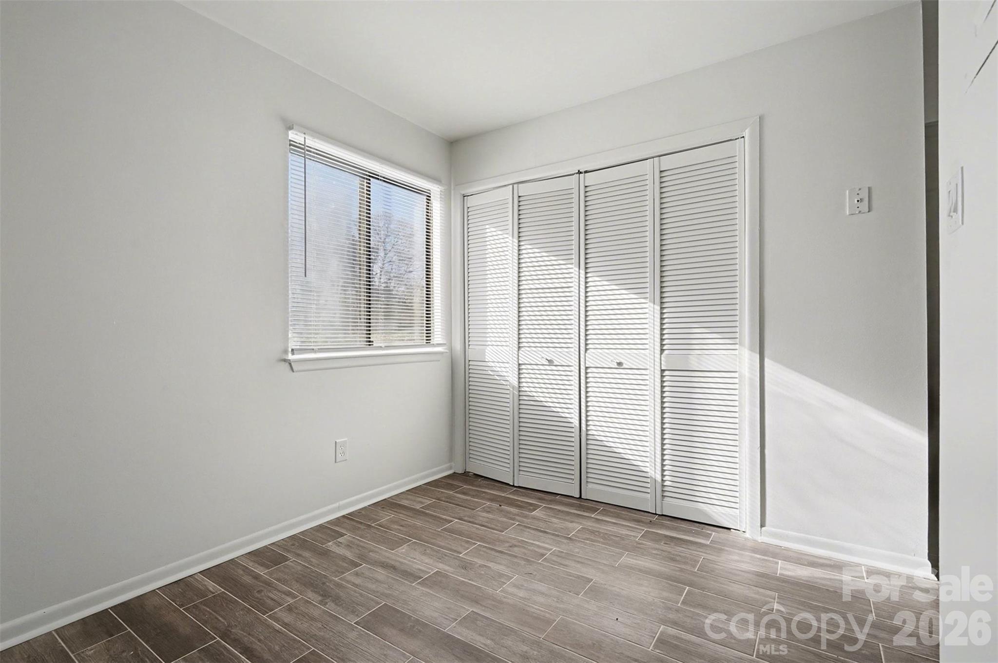 6148 Heath Ridge Court Charlotte, NC 28210 - Photo 12 of 27 an empty room with wooden floor and windows