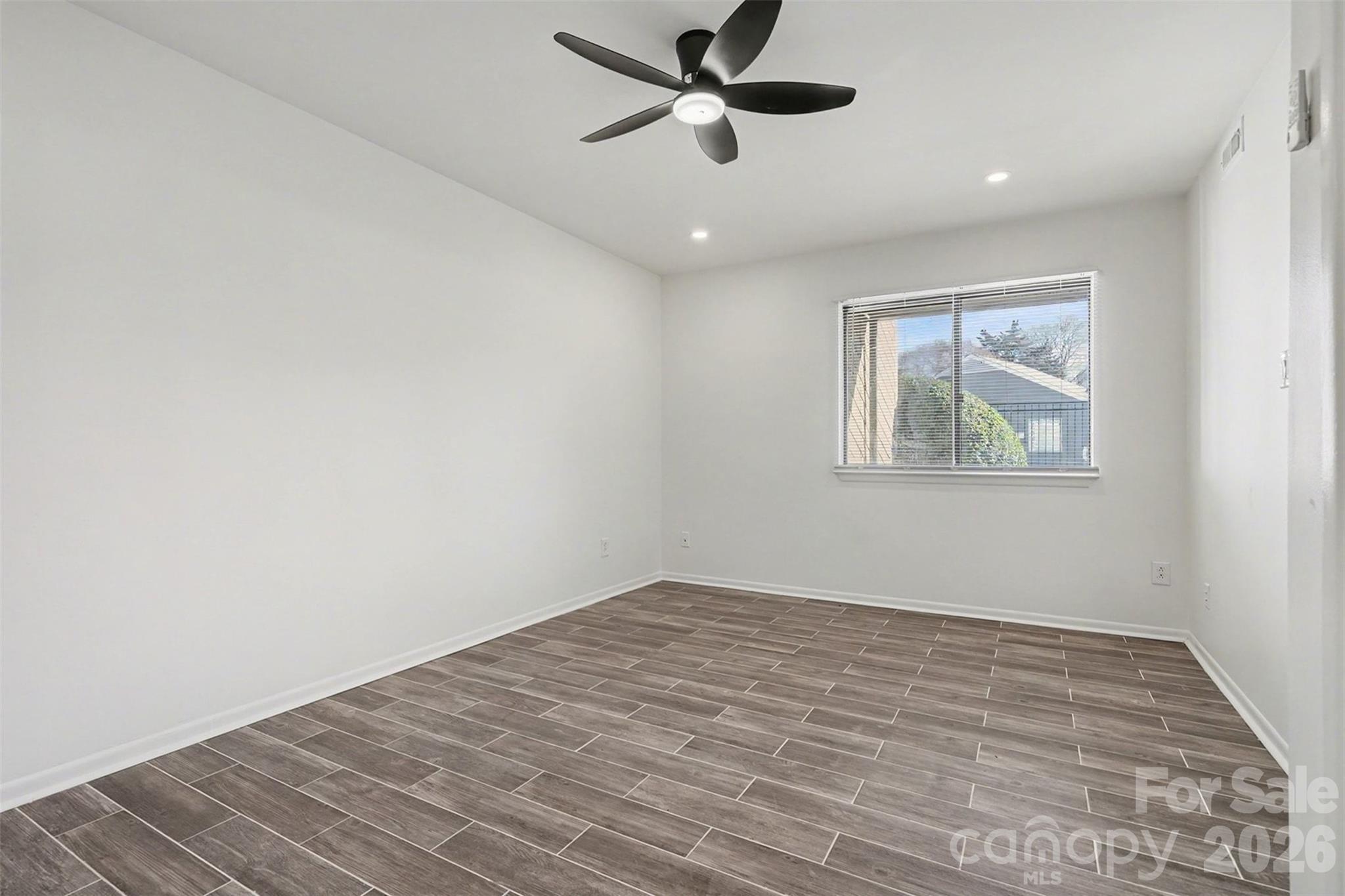 6148 Heath Ridge Court Charlotte, NC 28210 - Photo 23 of 27 an empty room with wooden floor and windows
