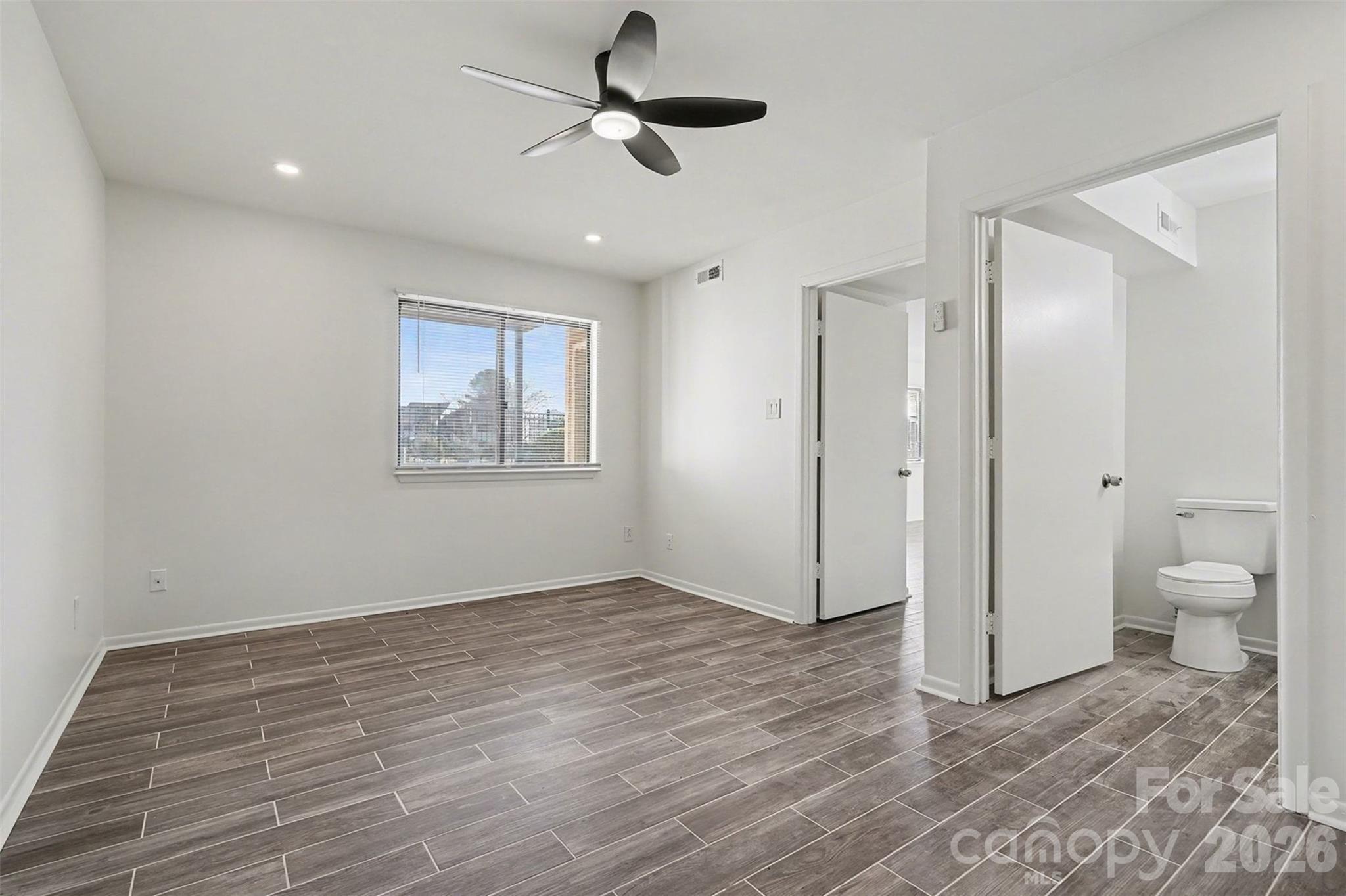6148 Heath Ridge Court Charlotte, NC 28210 - Photo 24 of 27 wooden floor in an empty room with a bathroom