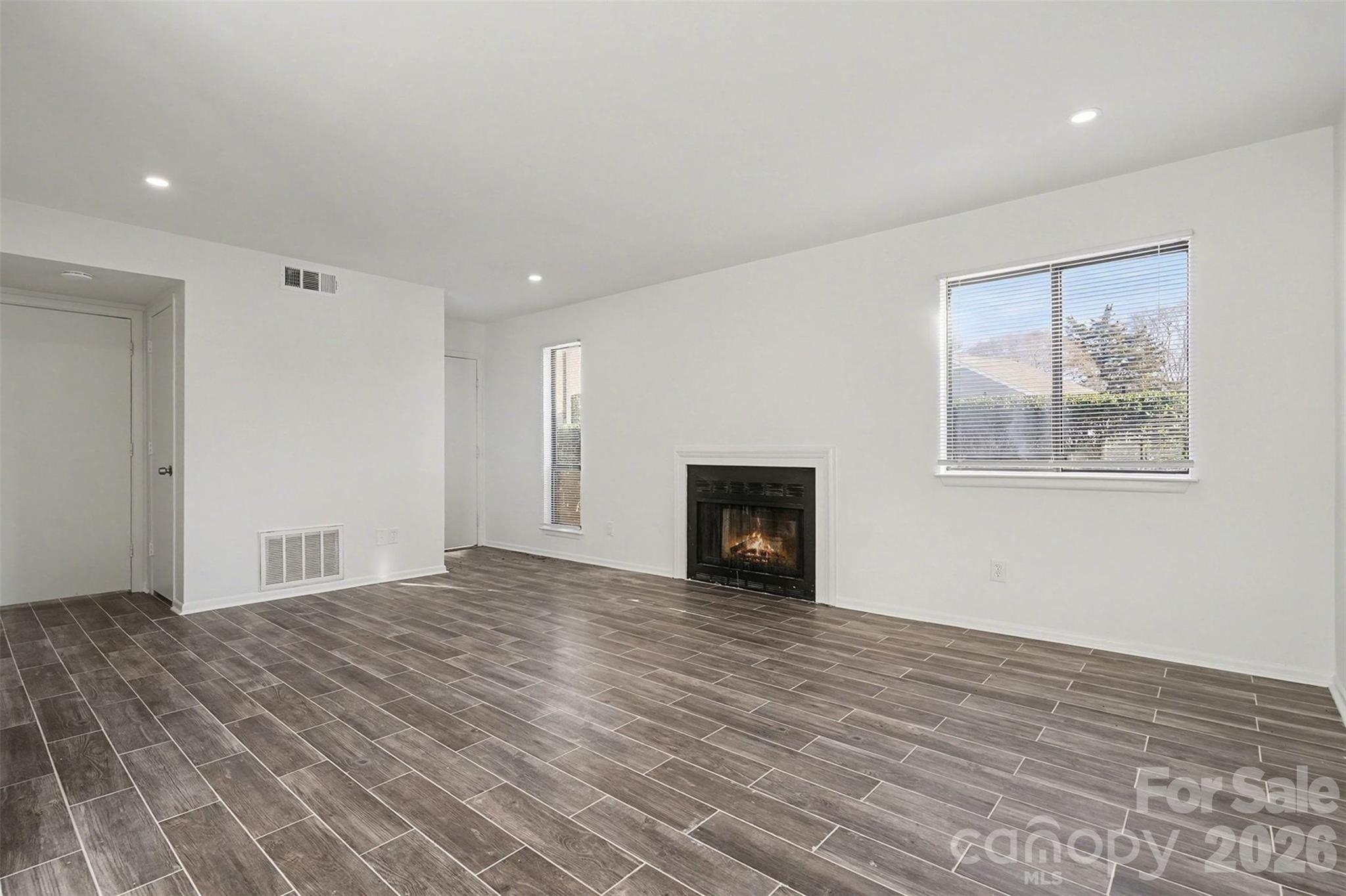 6148 Heath Ridge Court Charlotte, NC 28210 - Photo 4 of 27 a view of empty room with wooden floor and fireplace