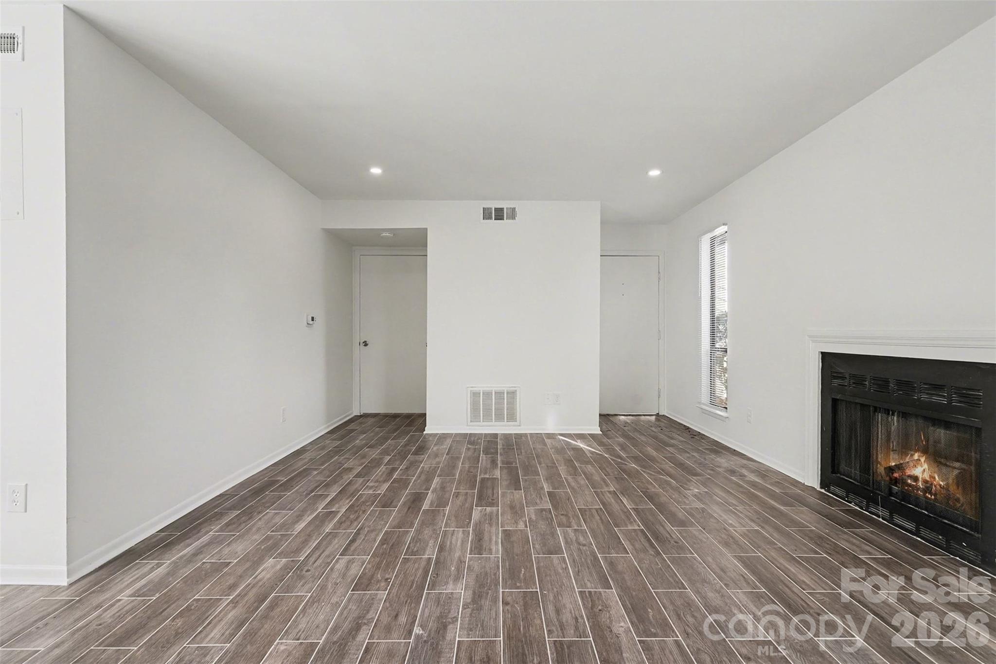 6148 Heath Ridge Court Charlotte, NC 28210 - Photo 5 of 27 a view of empty room with wooden floor and fireplace