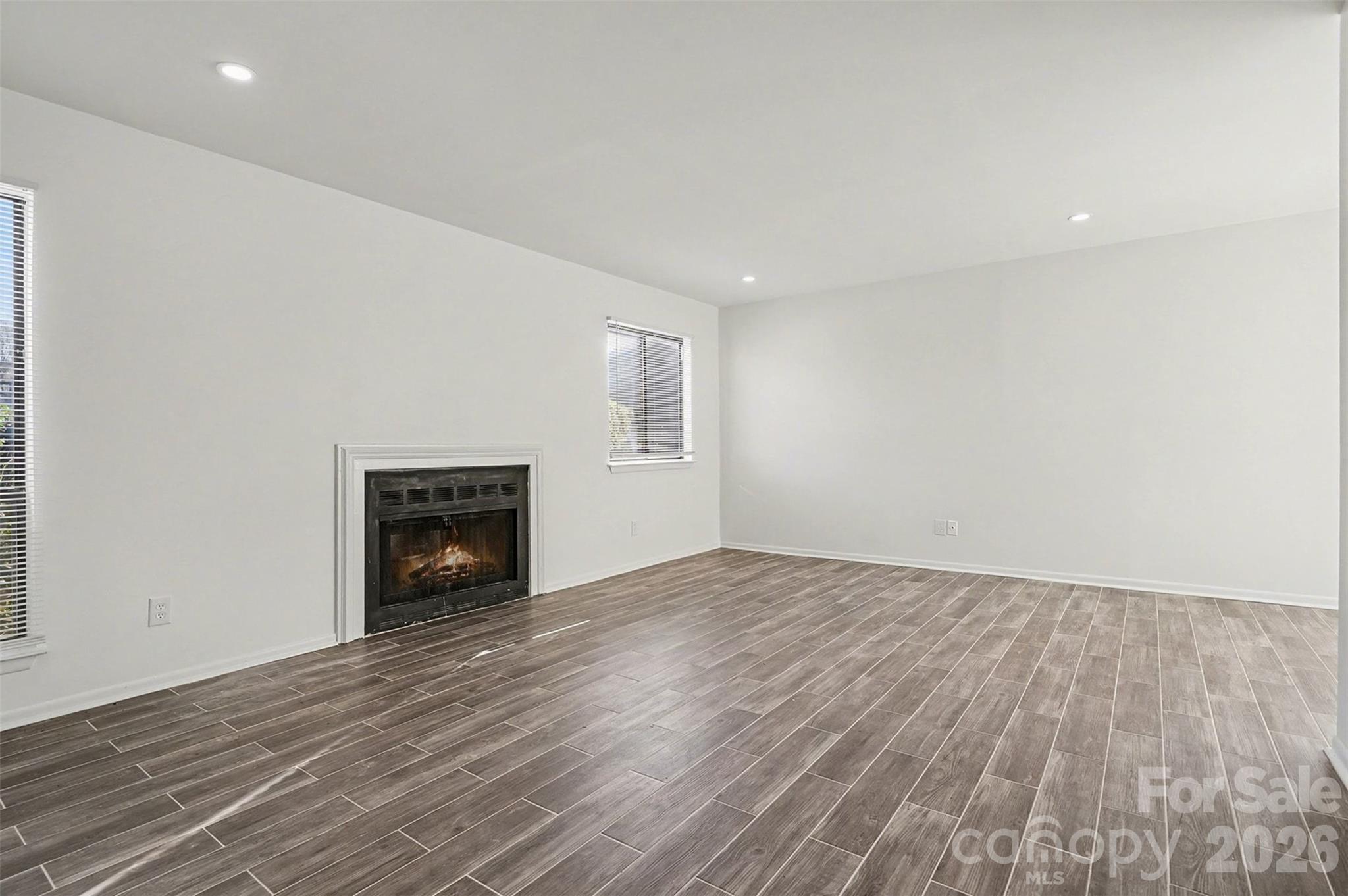 6148 Heath Ridge Court Charlotte, NC 28210 - Photo 6 of 27 a view of empty room with wooden floor and fireplace