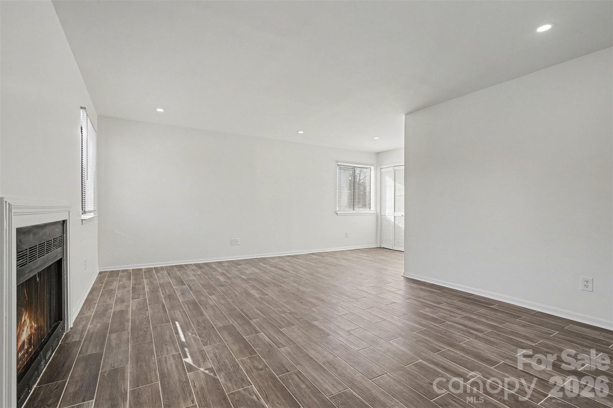 6148 Heath Ridge Court Charlotte, NC 28210 - Photo 7 of 27 a view of empty room with wooden floor and fireplace