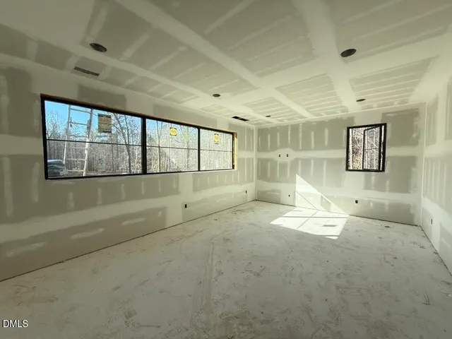 a view of an empty room with a fireplace and a window