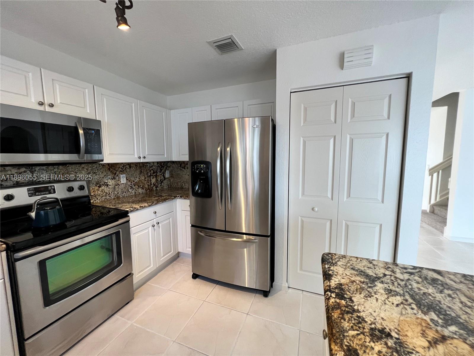 12247 Southwest 140th Street Miami, FL 33186 - Photo 32 of 86 a kitchen with stainless steel appliances granite countertop a refrigerator stove and microwave