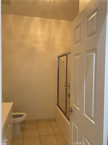 a bathroom with a granite countertop shower and a toilet