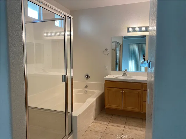 a bathroom with a bathtub sink vanity and mirror