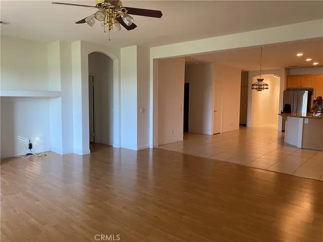 an empty room with wooden floor and chandelier