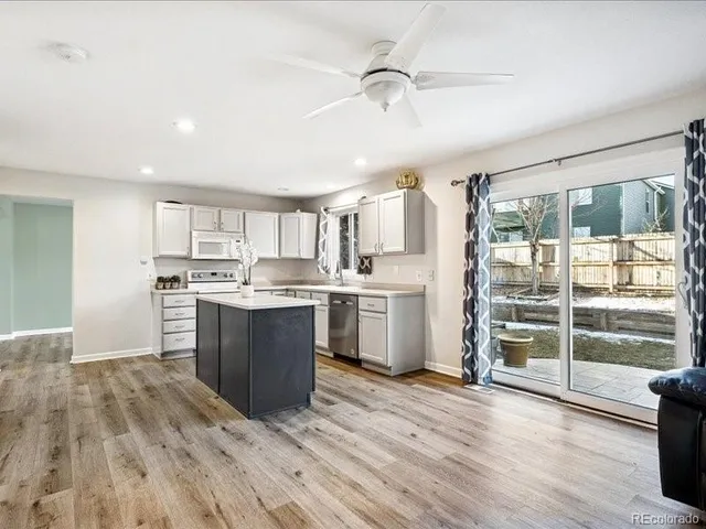 a large kitchen with kitchen island wooden floors and stainless steel appliances