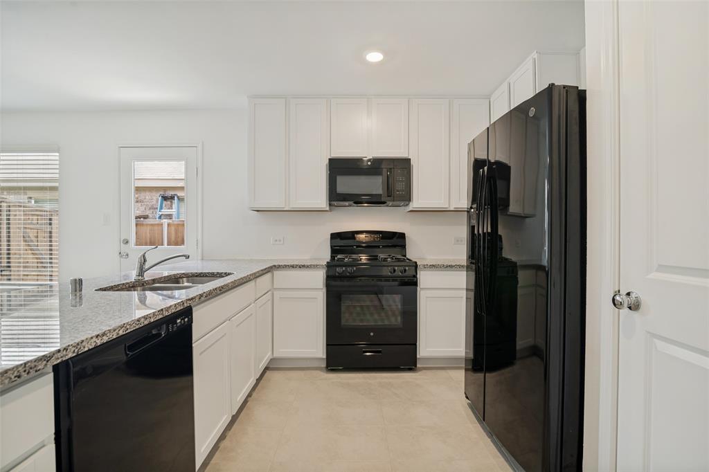 1345 Cider Street Forney, TX 75126 - Photo 6 of 15 a kitchen with granite countertop a refrigerator stove and sink