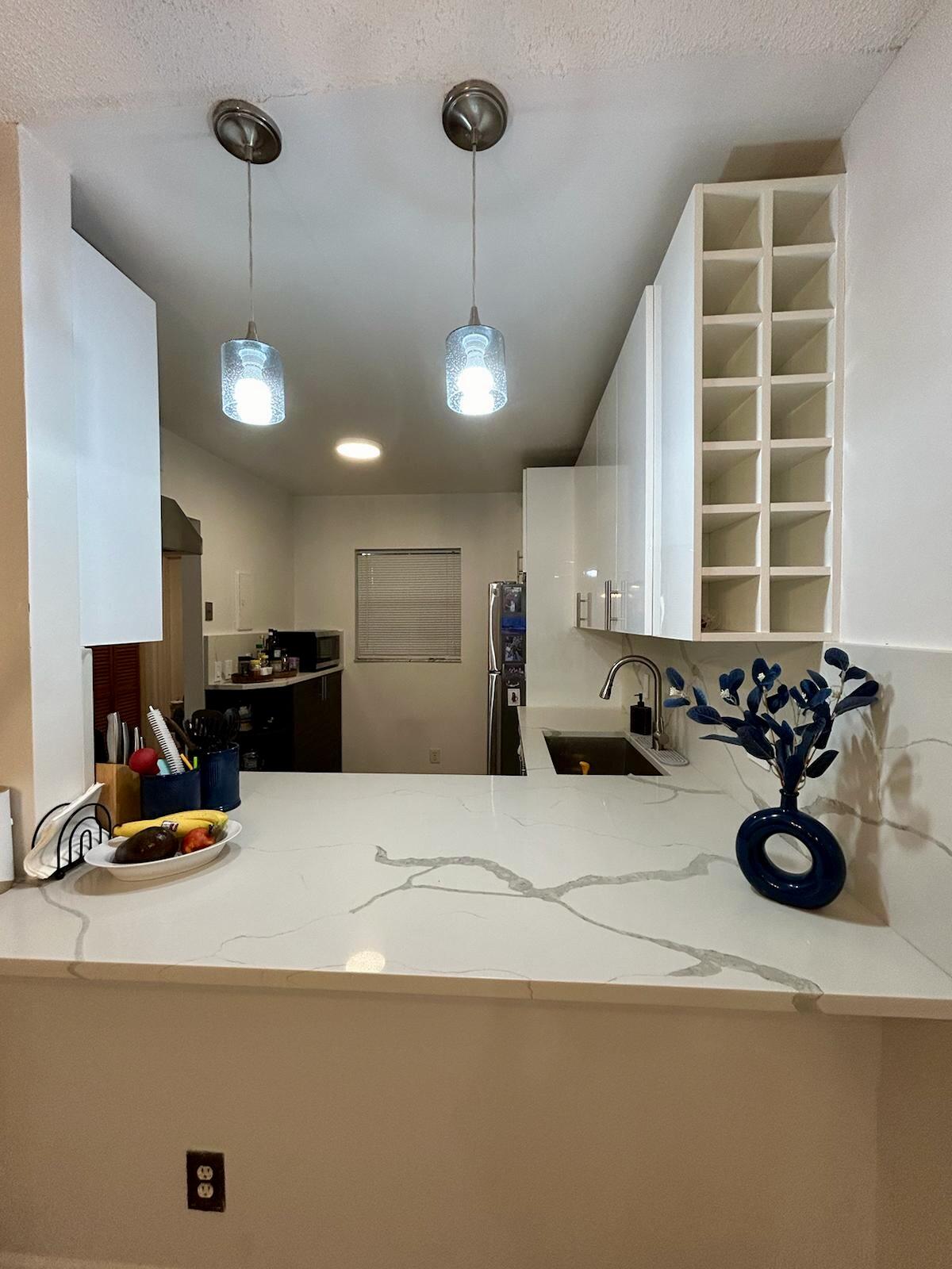 Undisclosed Address Delray Beach, FL 33445 - Photo 4 of 23 a kitchen with a refrigerator and a sink