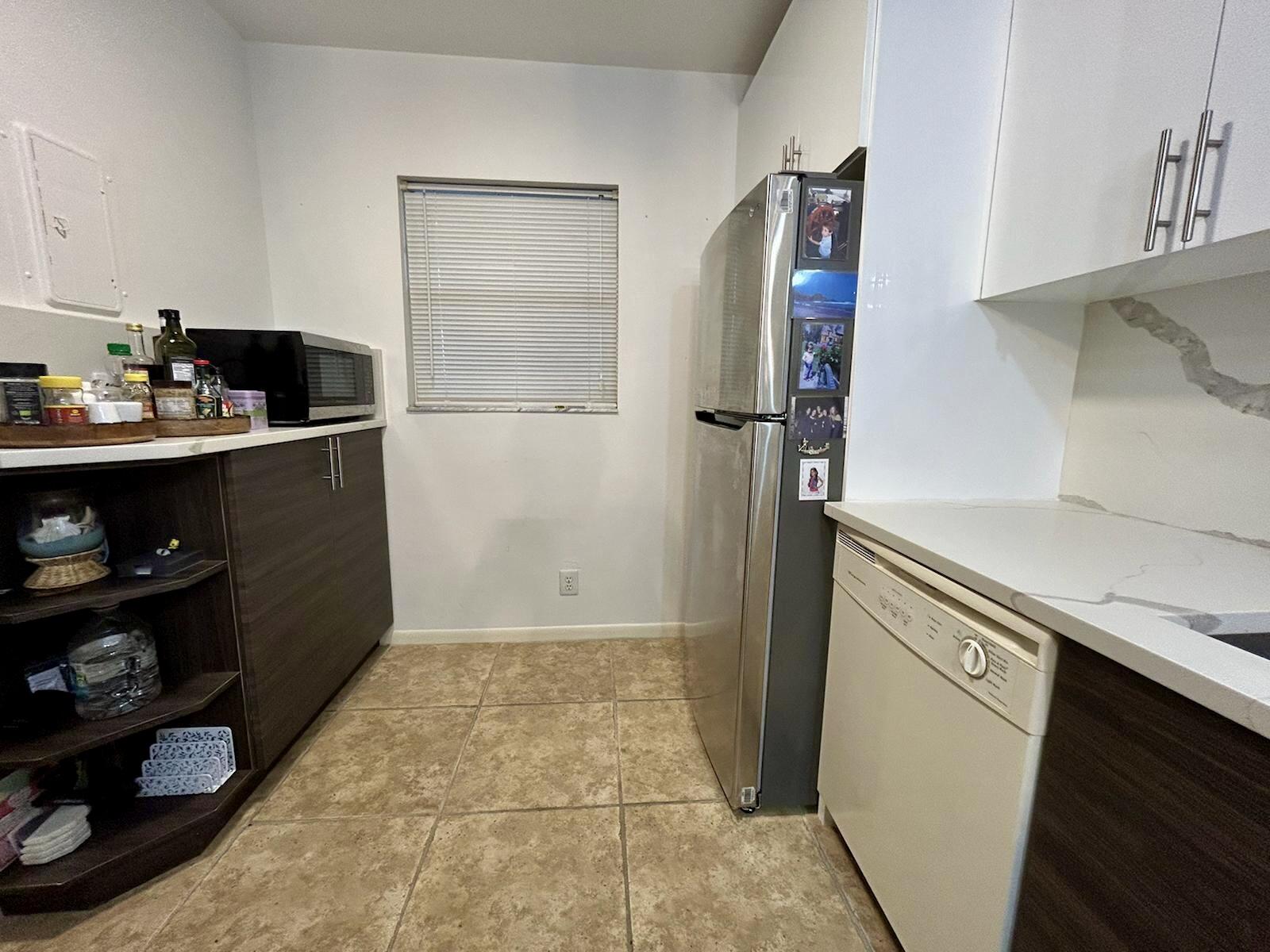 Undisclosed Address Delray Beach, FL 33445 - Photo 6 of 23 a kitchen with a refrigerator and cabinets