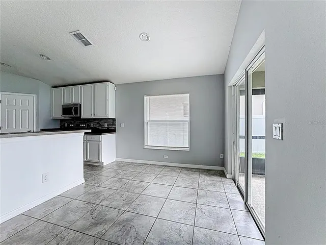 a view of a kitchen with furniture and an empty room