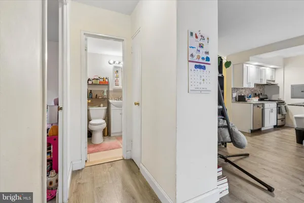a view of a hallway with bathroom and wooden floor
